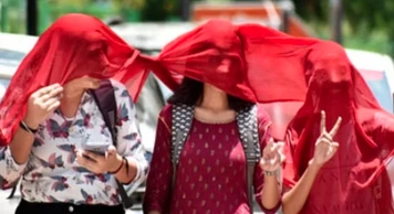 कानपुर में तेज धूप और उमस के बीच सड़क पर चलते लोग, मौसम विभाग ने बूंदाबांदी की संभावना जताई।