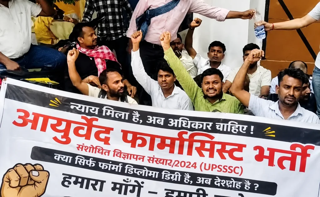 लखनऊ में आयुर्वेदिक फार्मासिस्ट भर्ती 2024 के अभ्यर्थी परीक्षा तिथि की मांग को लेकर प्रदर्शन करते हुए