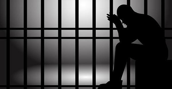 ब्राजील की जेल में किताब पढ़ते हुए कैदी, शिक्षा के माध्यम से सजा कम करने की योजना का प्रतीकात्मक दृश्य।