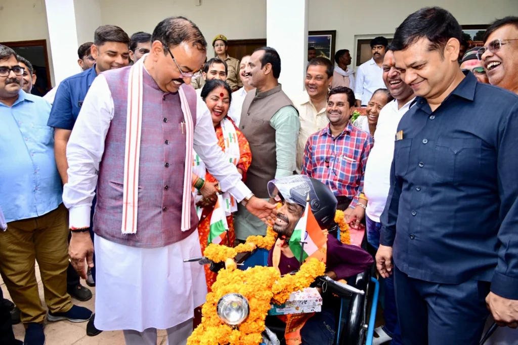 कौशाम्बी के दीनानाथ को उप मुख्यमंत्री केशव प्रसाद मौर्य ट्राई-साइकिल सौंपते हुए